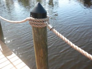 A rope tied to the side of a wooden post.