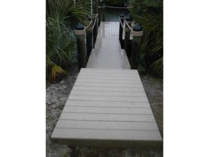 A dock with a wooden walkway going over it.