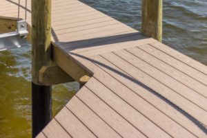 A dock with a wooden deck and water.