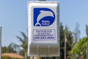 A sign for hooker marine on the side of a pole.