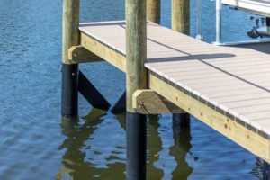 A dock with a pole and railing in the water.
